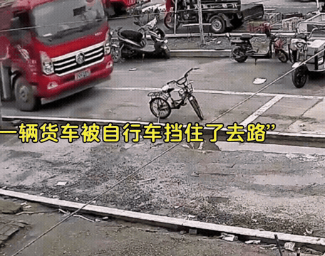 马路中间停了一辆自行车，大妈帮忙挪开，路面塌陷，卡车掉下去了.gif