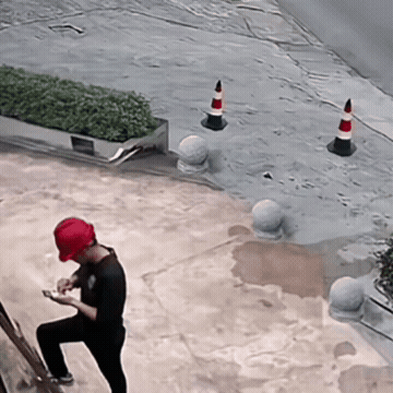 飞来千年杀，车撞飞锥桶打到人屁股.gif